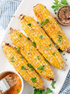 air fried corn cobs topped with parsley on a plate