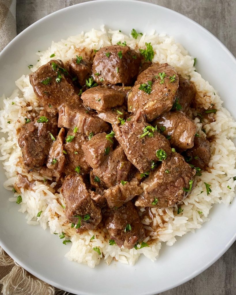 overhead shot of beef tips & rice in a white bowl