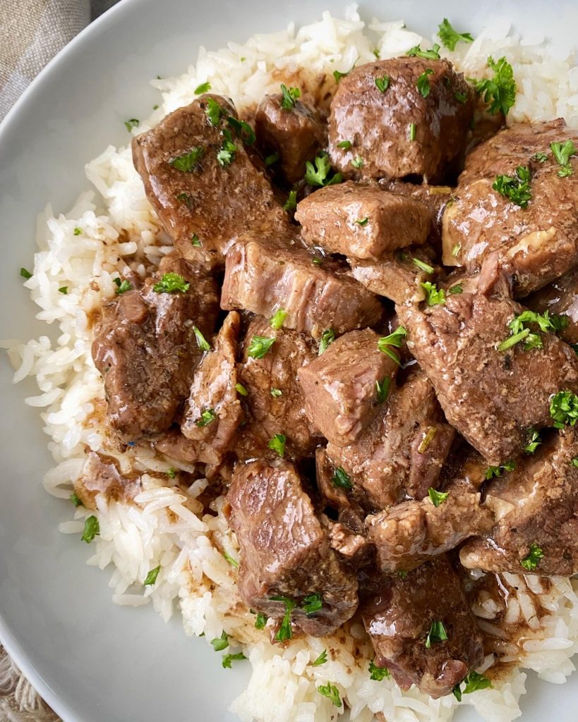 close up shot of beef tips & rice in a white bowl