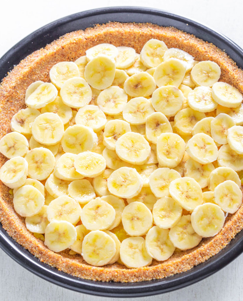 crushed pineapples and banana slices on top of graham cracker pie crust