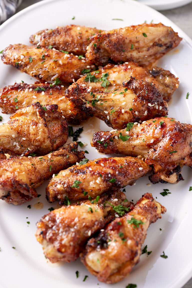 honey garlic chicken wings on white platter with garnish