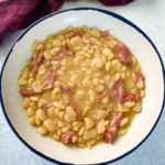 lima beans and smoked turkey in a white bowl