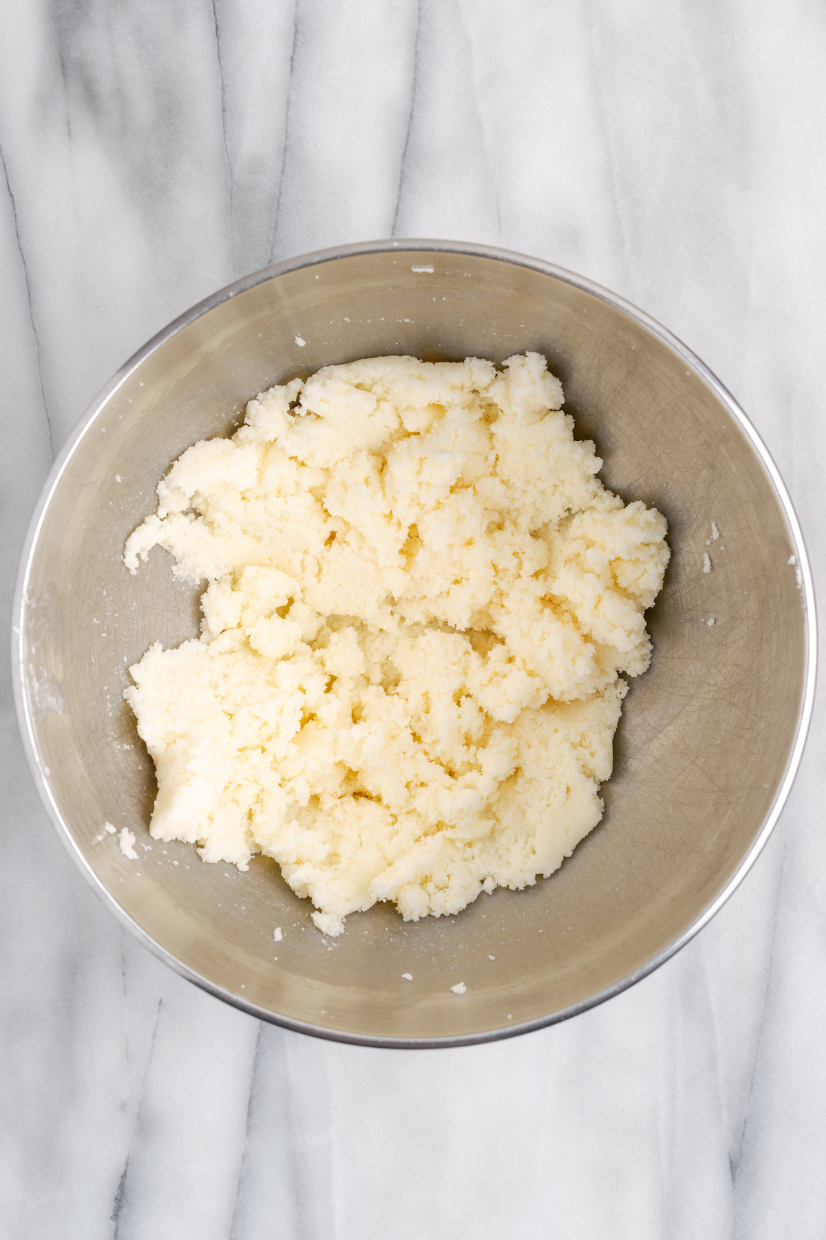 Overhead view of creamed vegan butter and sugar in mixing bowl