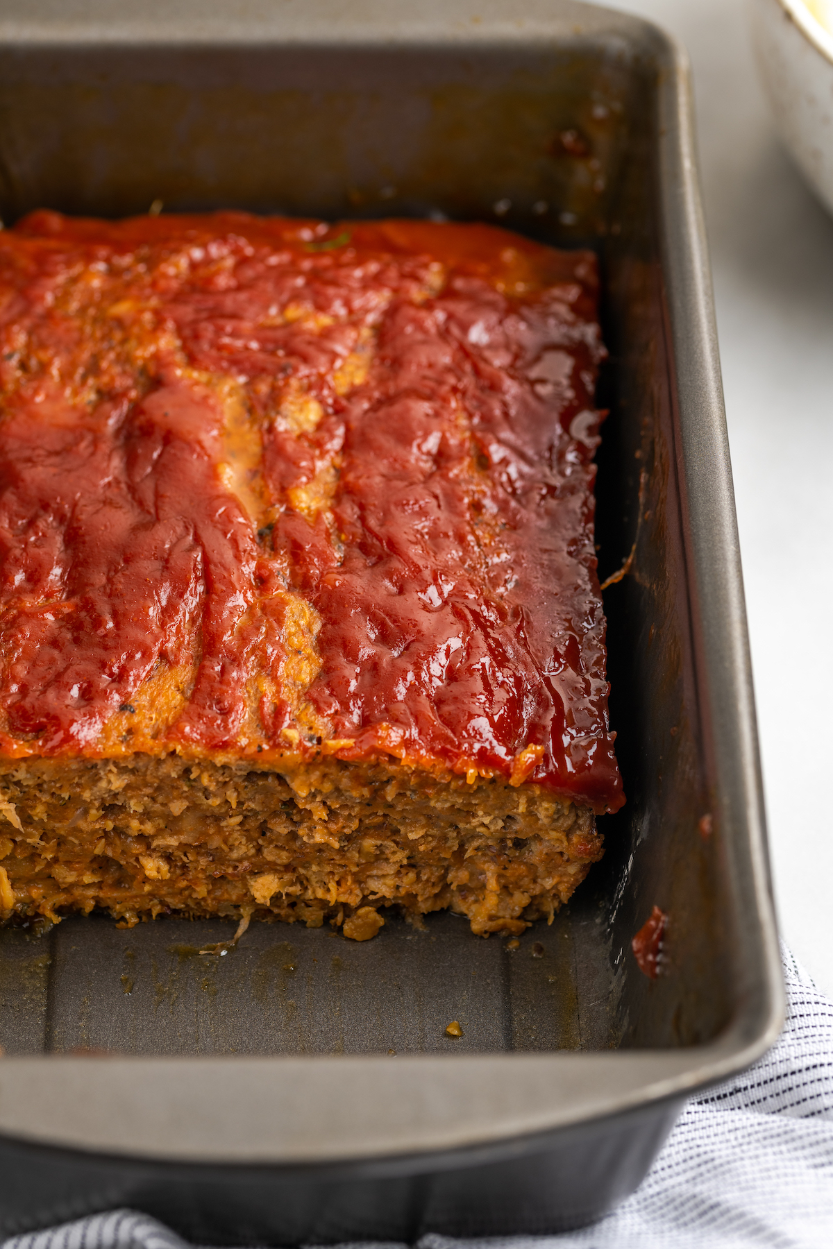 Vegan Southern meatloaf in loaf pan with slices removed