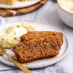 Vegan Southern meatloaf slices on plate with mashed potatoes and fork