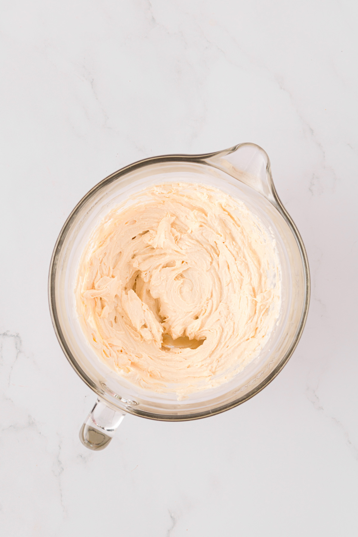 Overhead view of butter and cream cheese mixture in mixing bowl