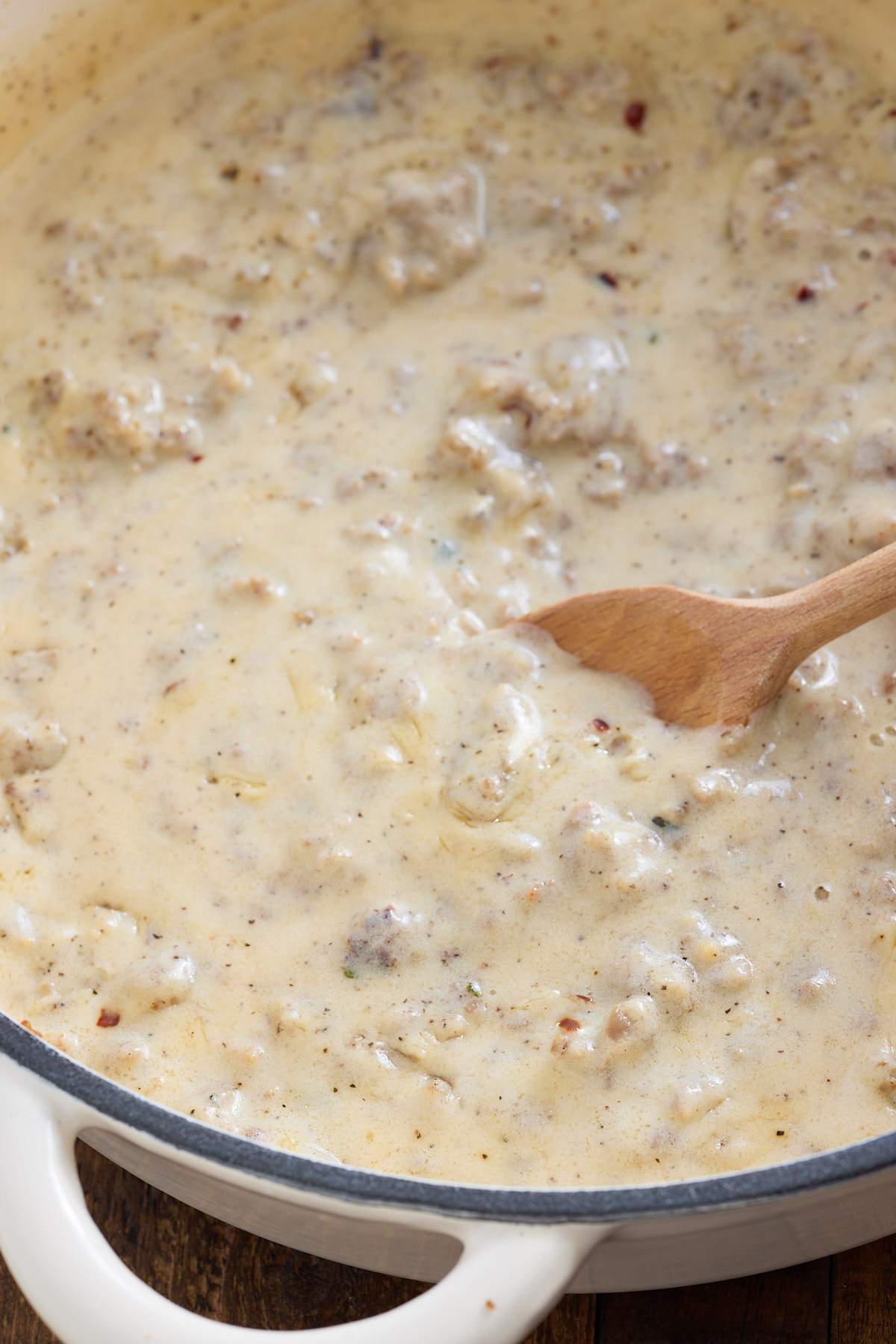 sausage gravy in pan made with a spoon stick in it