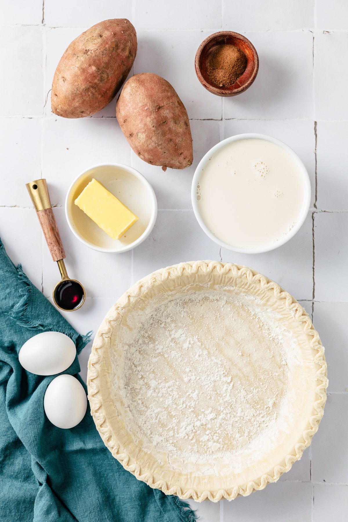 Pie crust, Sweet potatoes, Butter, Sweetened condensed milk, Eggs, Cinnamon, Ground nutmeg, Vanilla extract on separate bowls