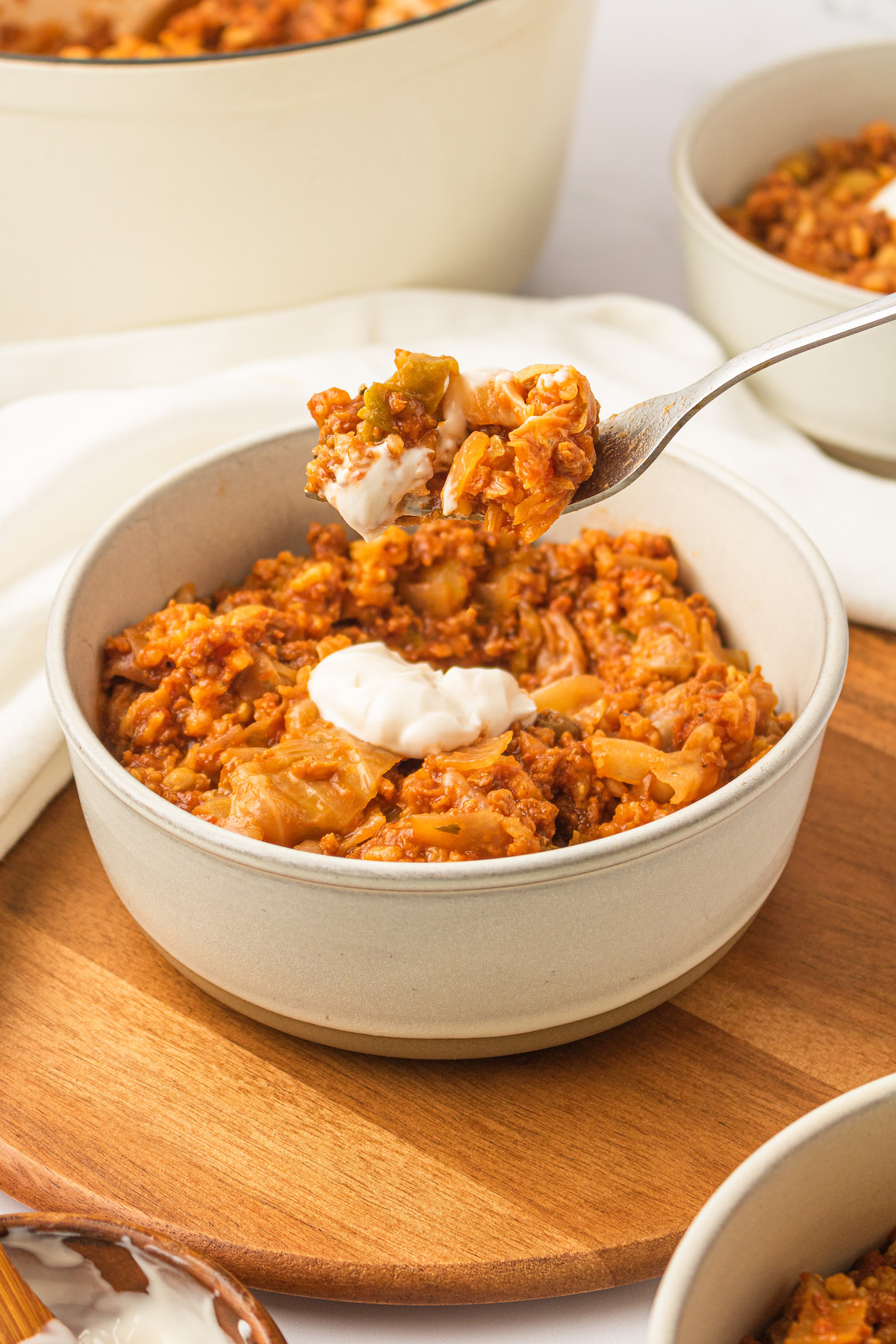 Lifting forkful of vegan unstuffed cabbage rolls from bowl