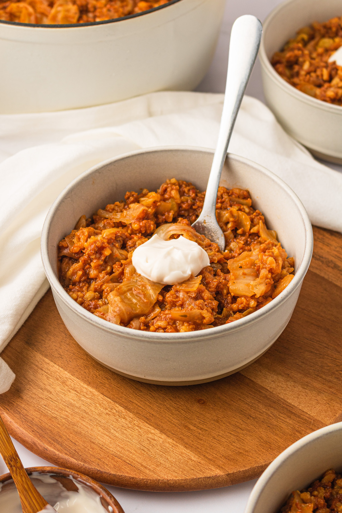 Vegan unstuffed cabbage rolls in bowl with spoon and sour cream