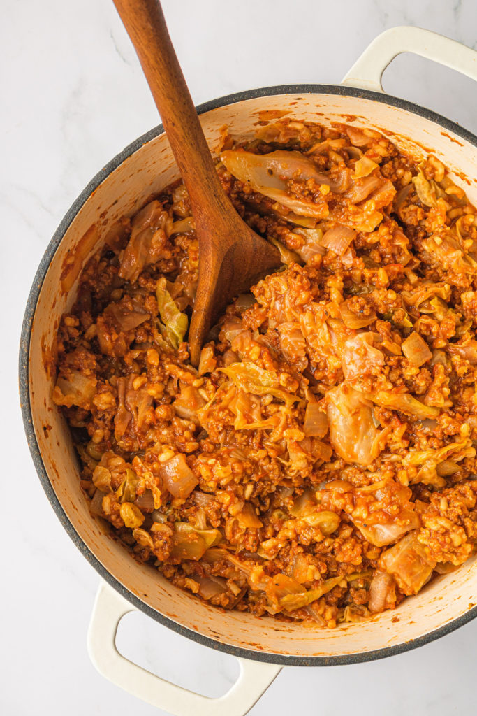 Overhead view of unstuffed cabbage rolls in Dutch oven