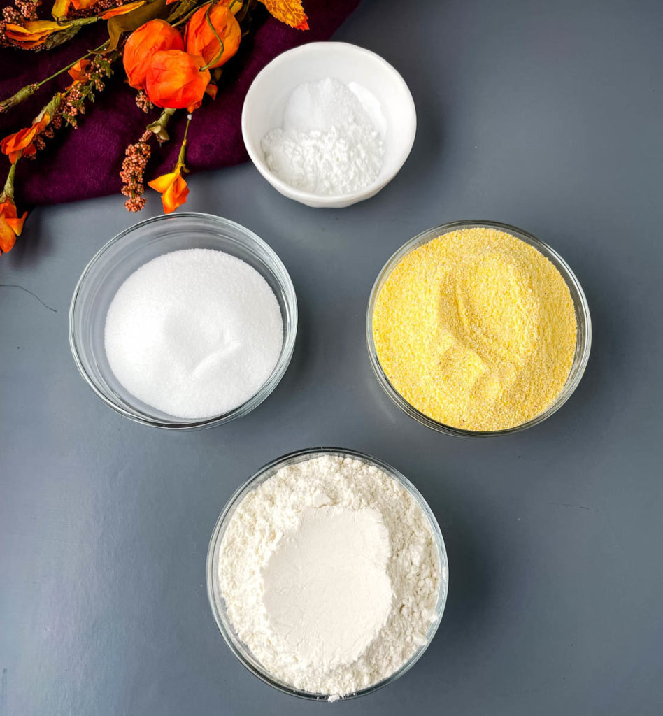cornmeal, flour, baking powder, and sweetener in separate glass bowls