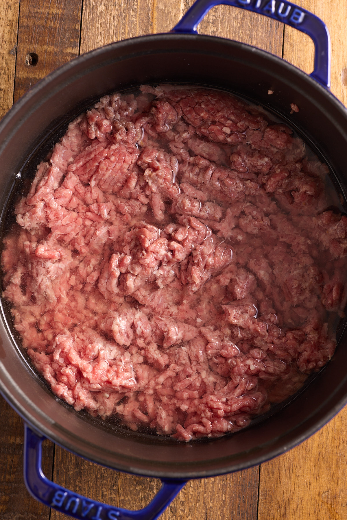 raw beef covered with water in heavy pot