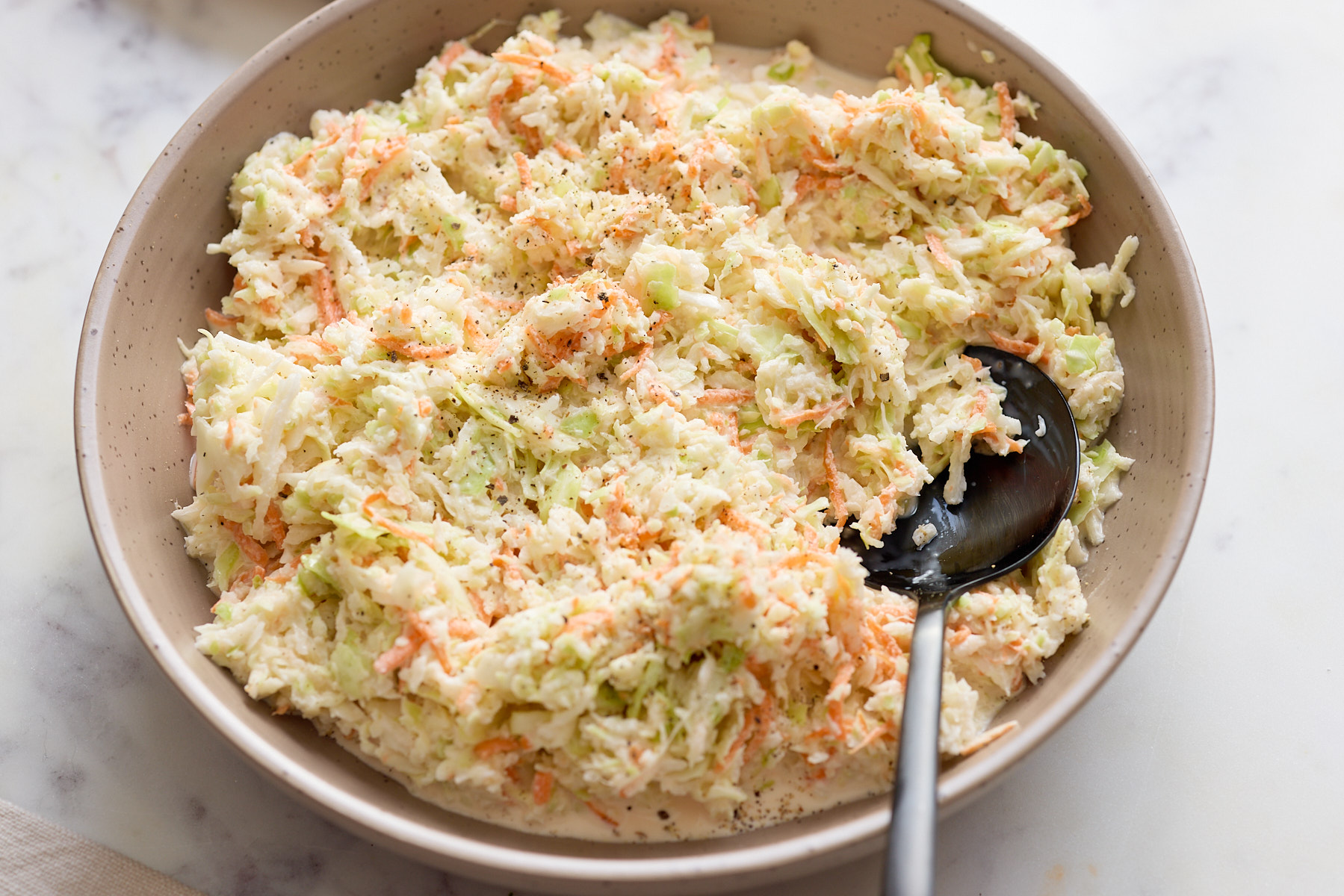 coleslaw on bowl with spoon sticking out