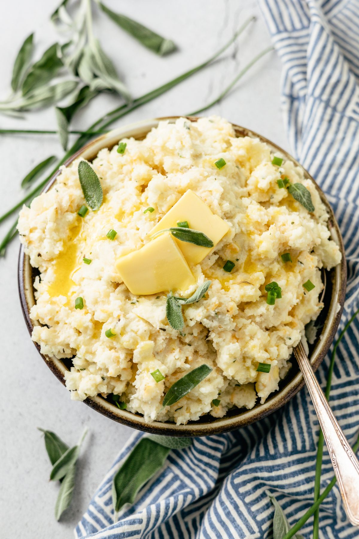 Close-up photo of Mashed Potatoes with Cheese topped with butter in a large bowl