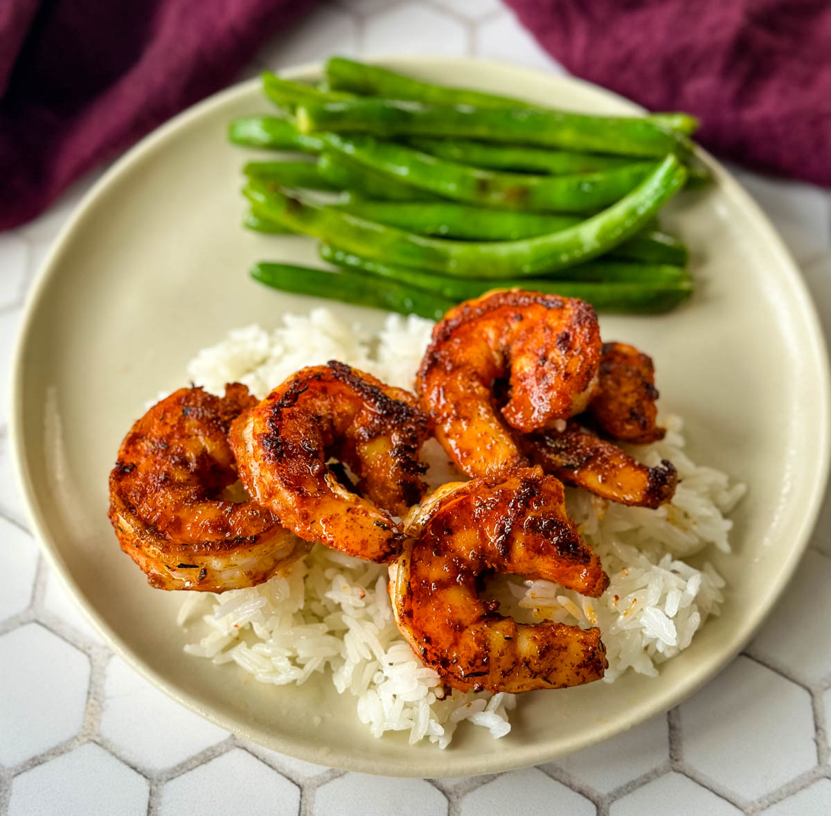 cooked Cajun shrimp with rice and green beans on a plate