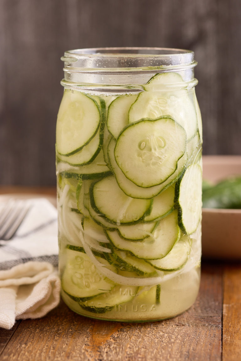 refrigerator pickles in glass jar on wood background