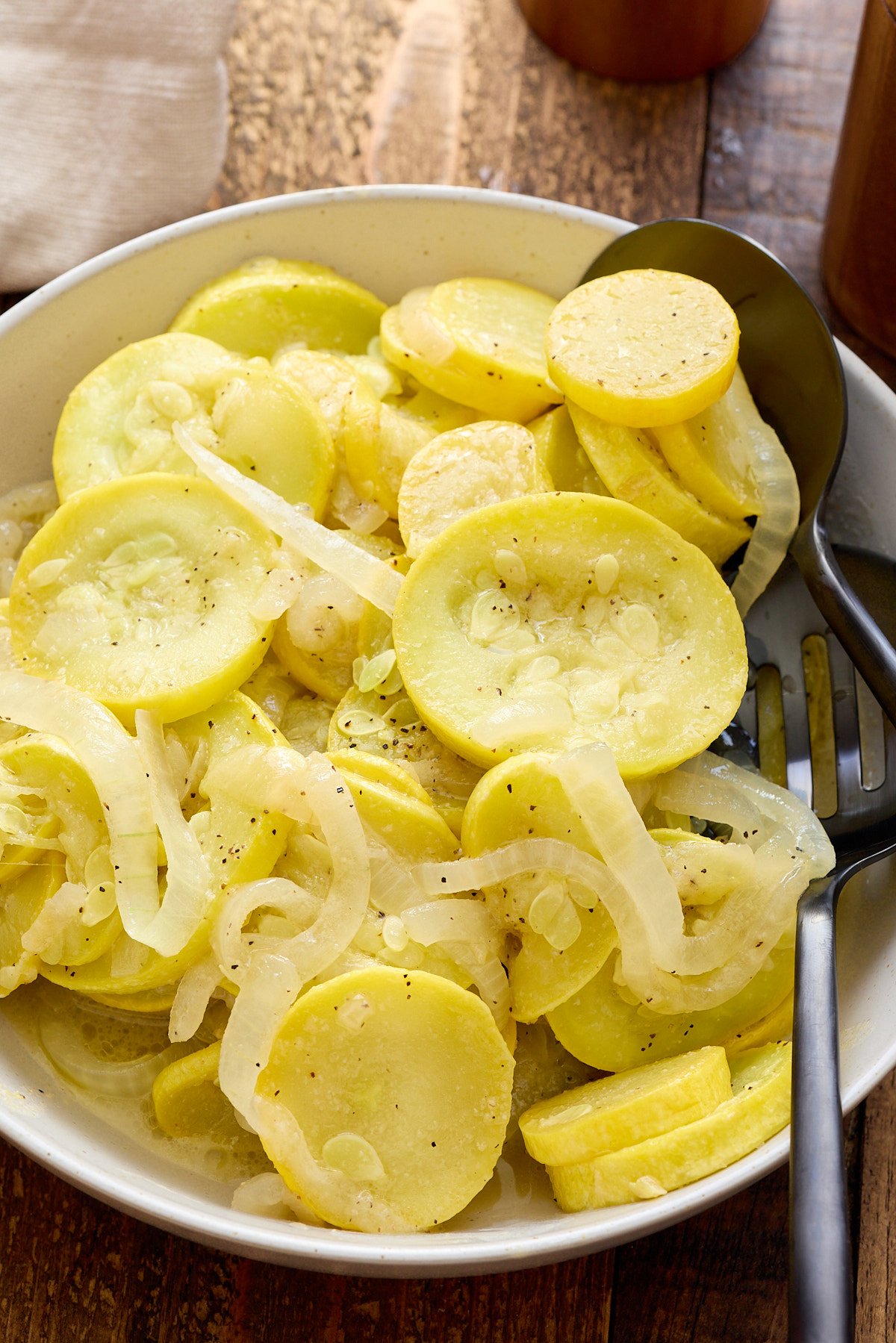 sauteed yellow squash on a plate with fork on side