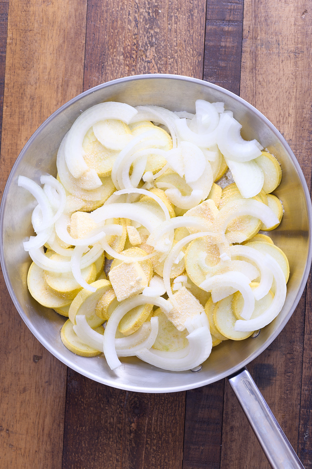 raw yellow squash and onions in skillet