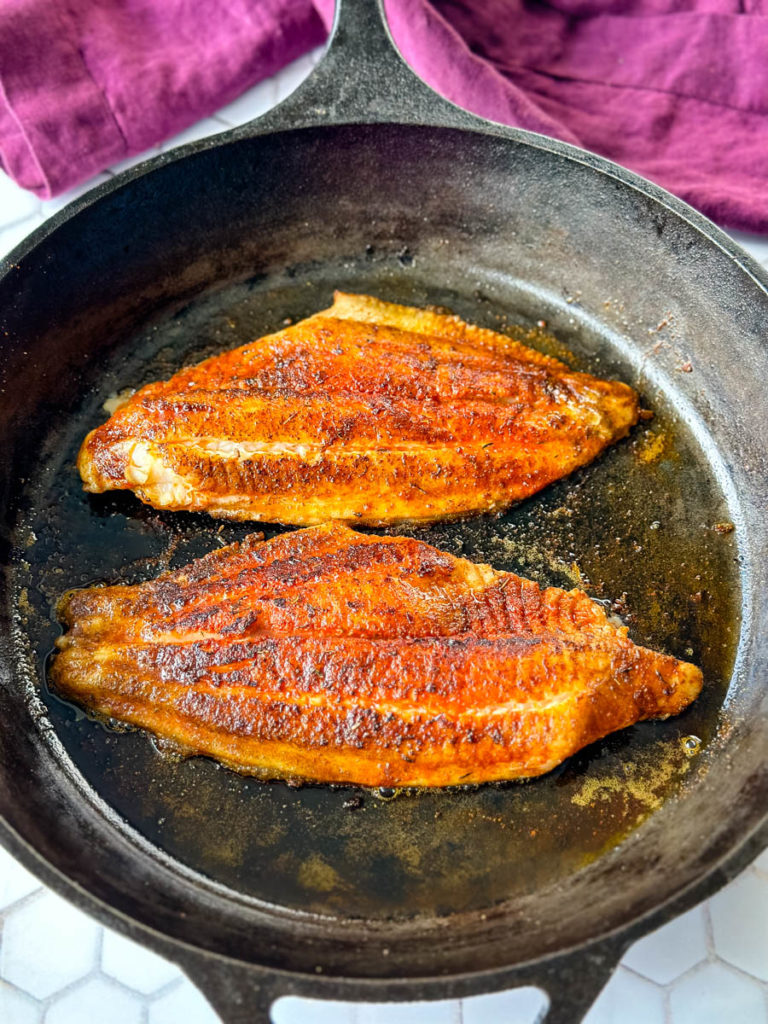 cooked Cajun fish in a cast iron skillet