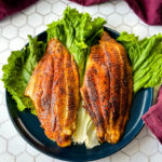 Cajun fish on a bed of lettuce on a blue plate