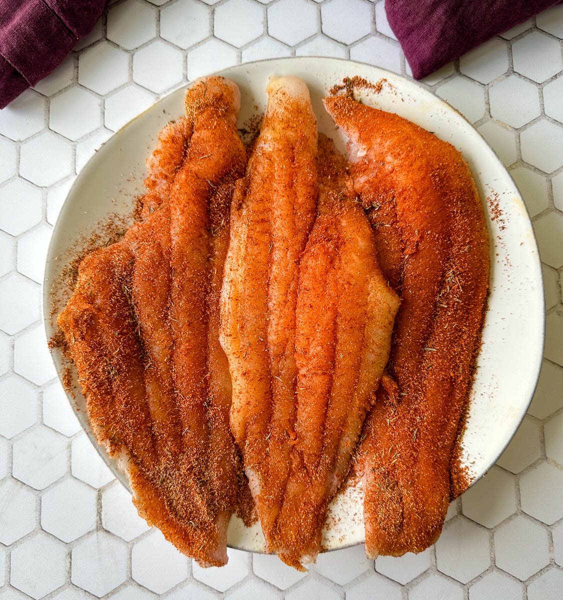 Cajun seasoned raw whitefish catfish on a plate