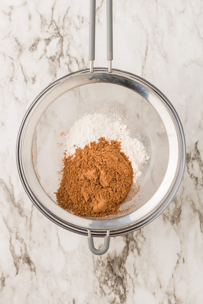 Overhead view of flour and cocoa powder in sieve