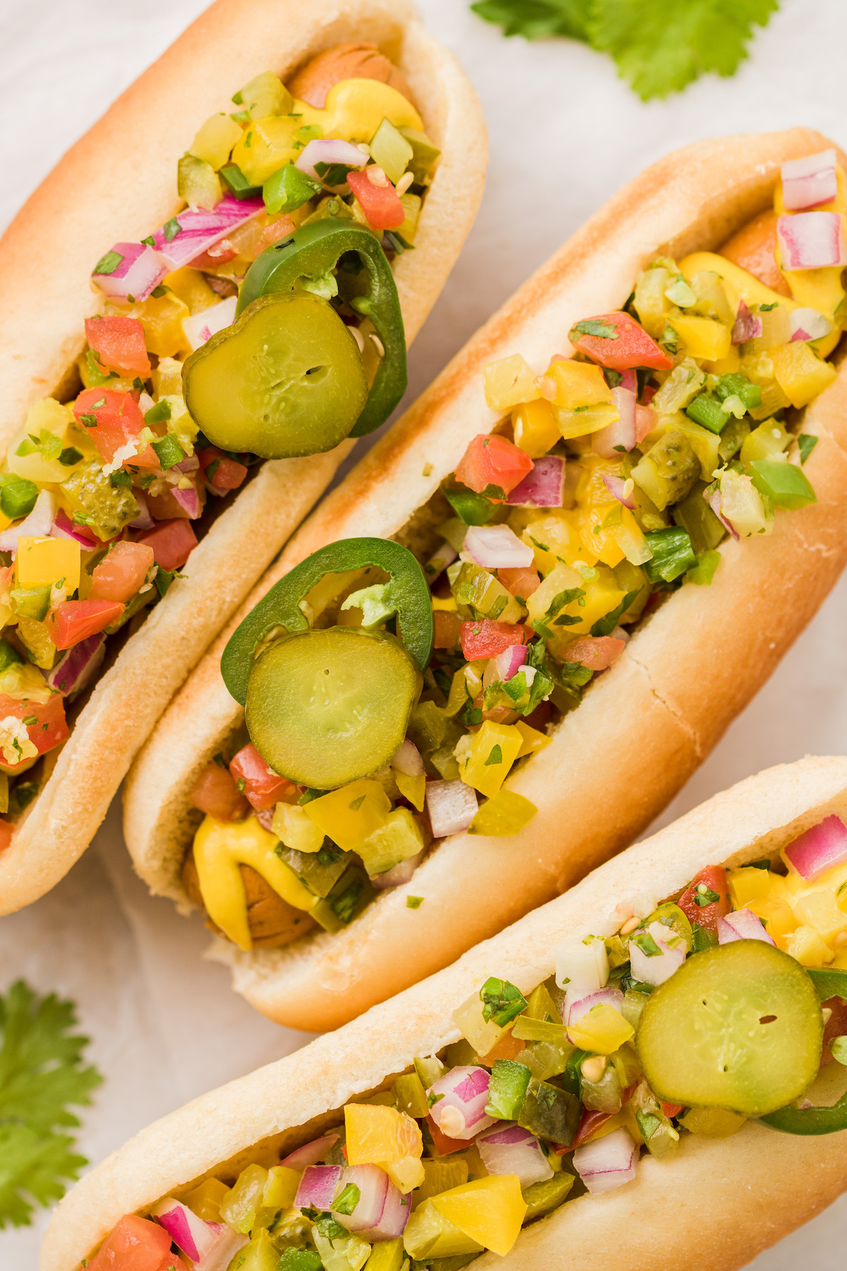 Overhead view of hot dogs topped with pickle de gallo