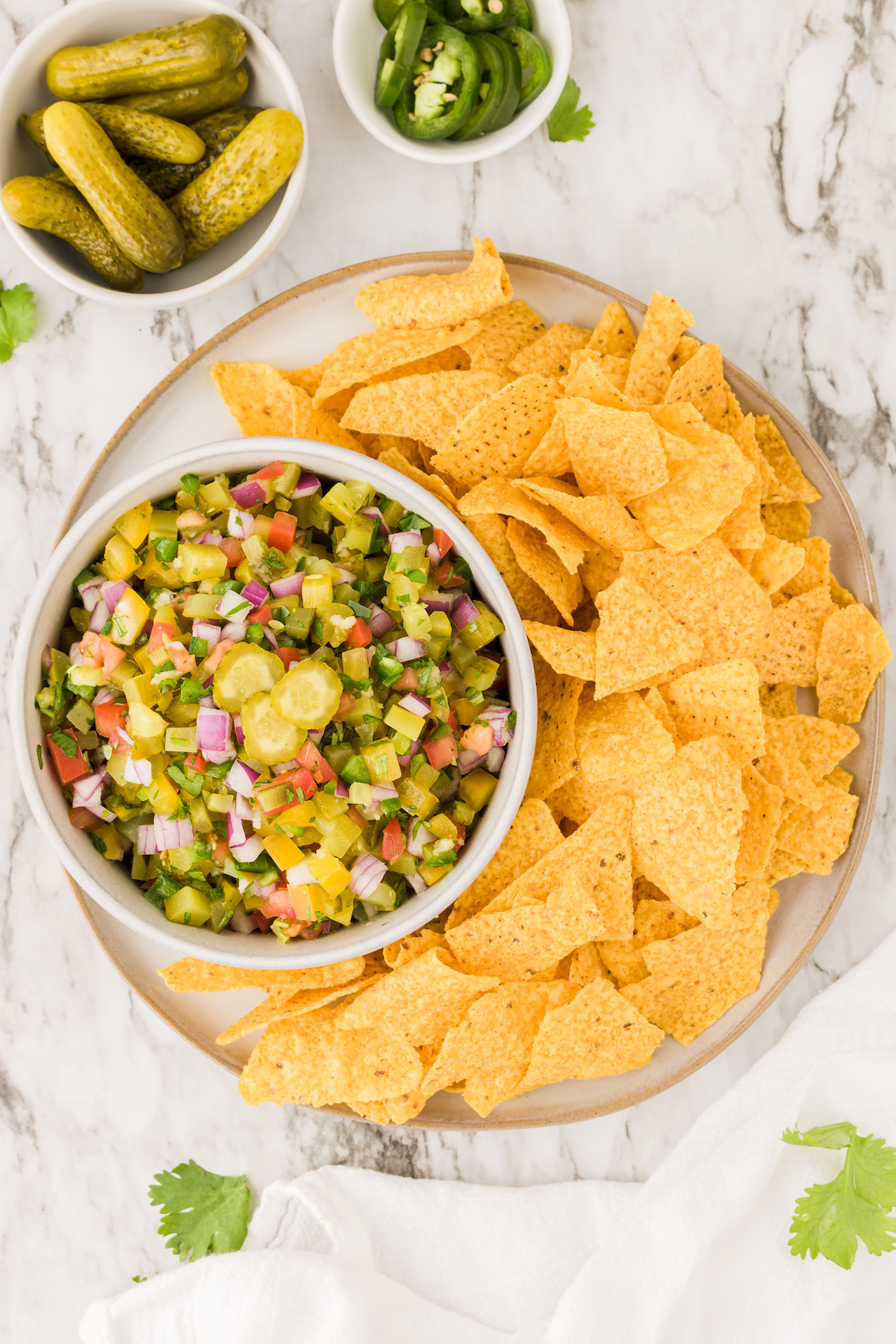 Overhead view of tortilla chips and bowl of pickle de gallo on tray