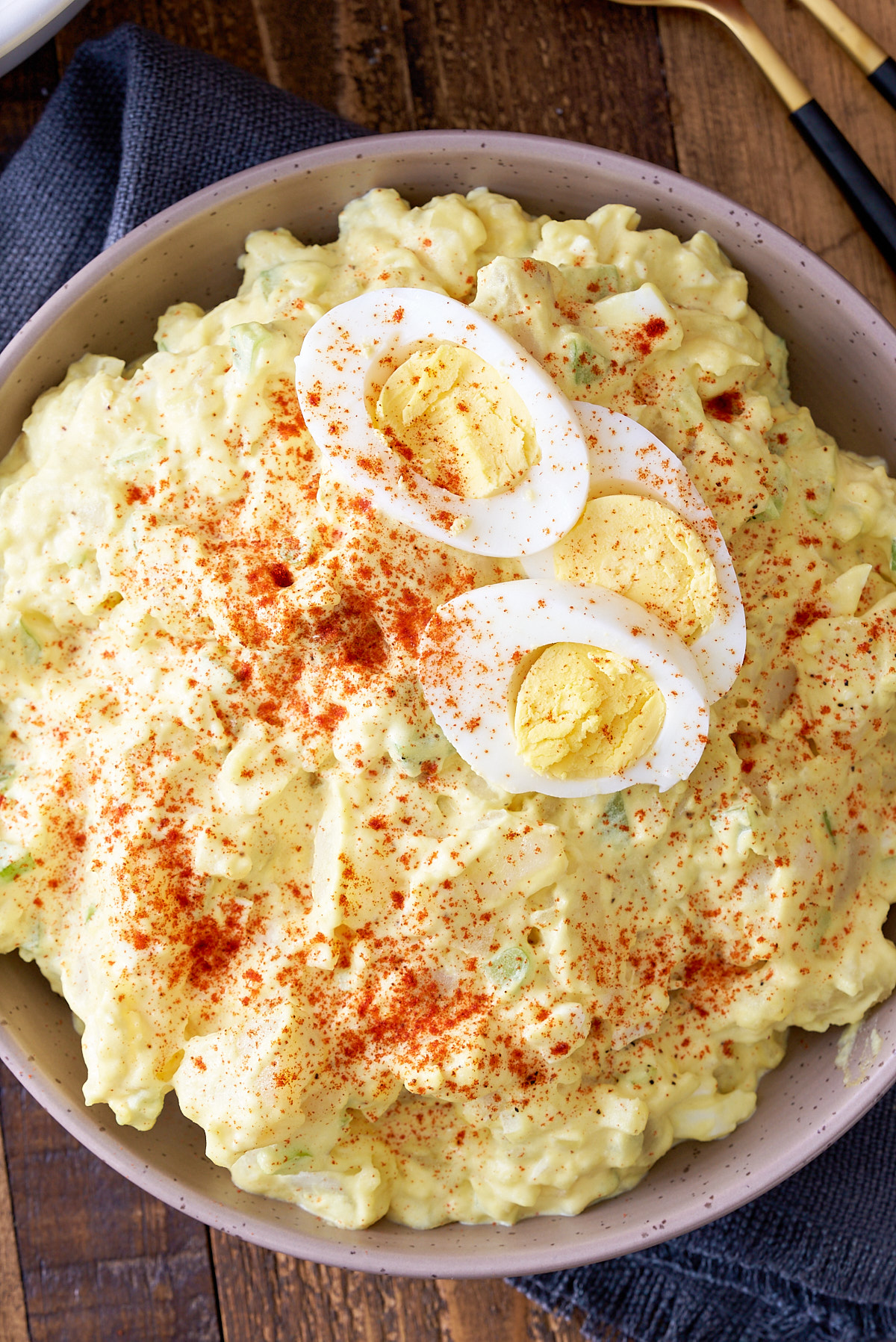 southern potato salad in bowl garnished with eggs and paprika