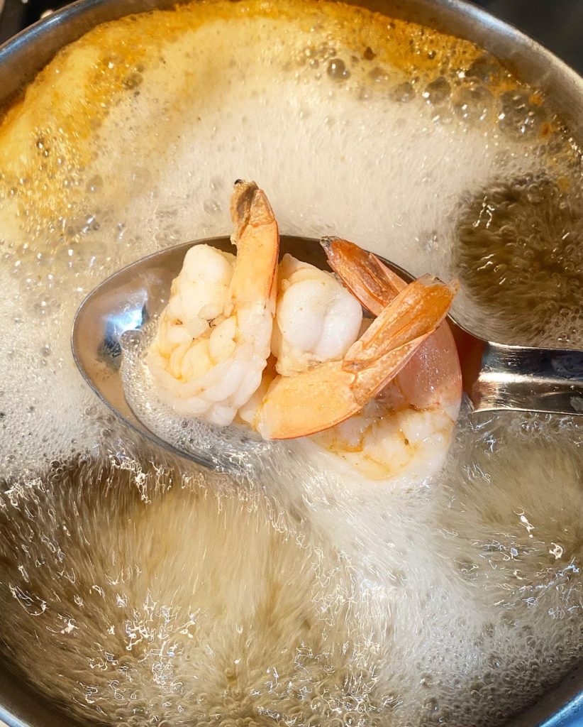overhead shot of shrimp boiling in water