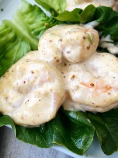 close up shot of shrimp remoulade on green lettuce