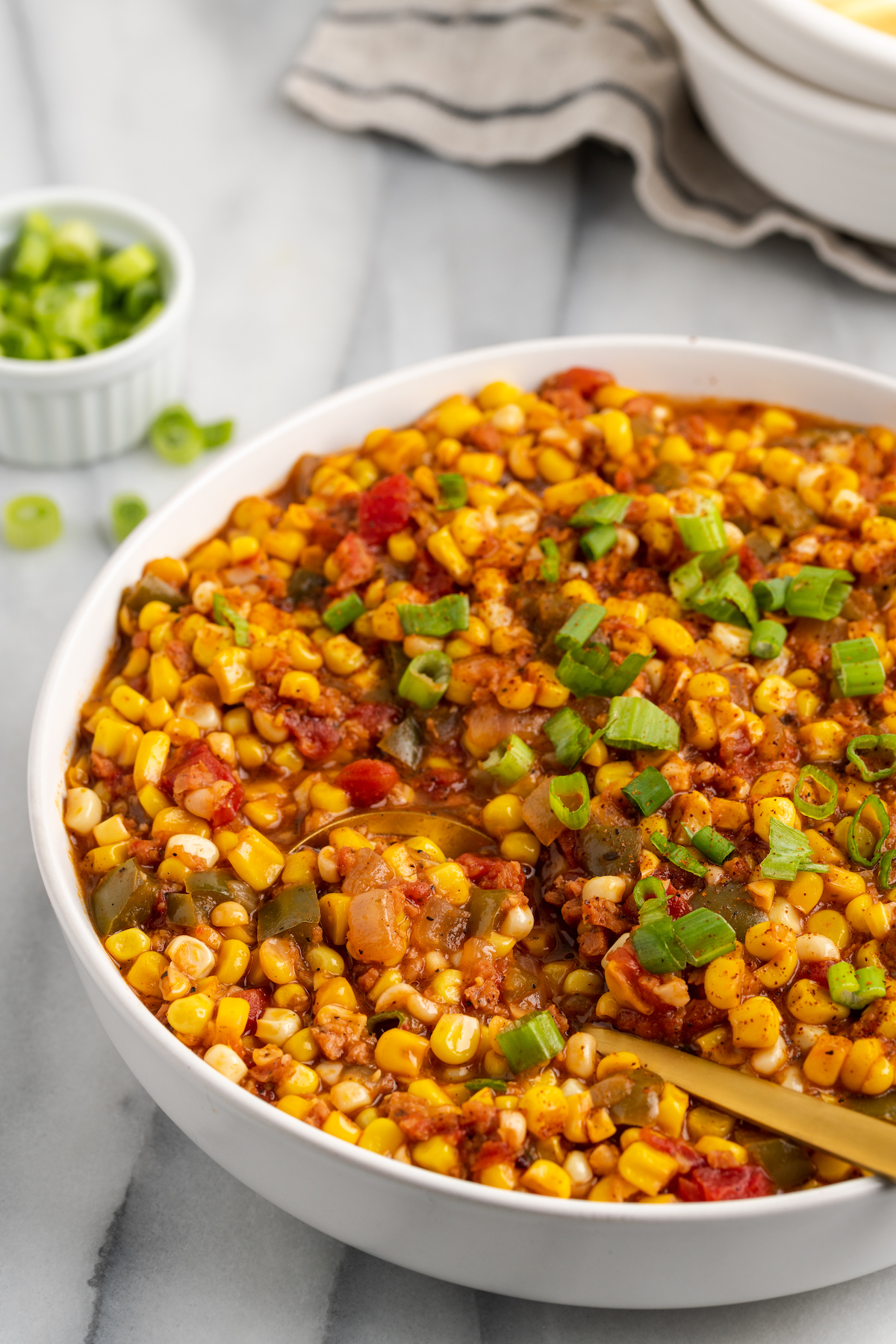 Large bowl of vegan corn maque choux with serving spoon