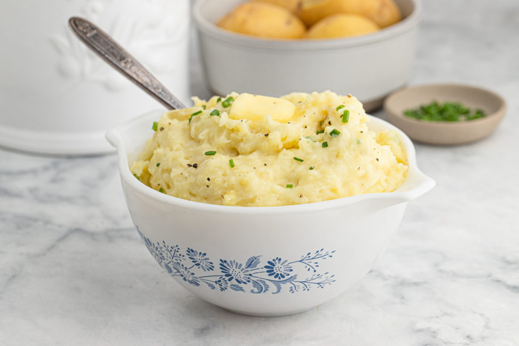 A large country bowl filled with buttermilk mashed potatoes ready to serve