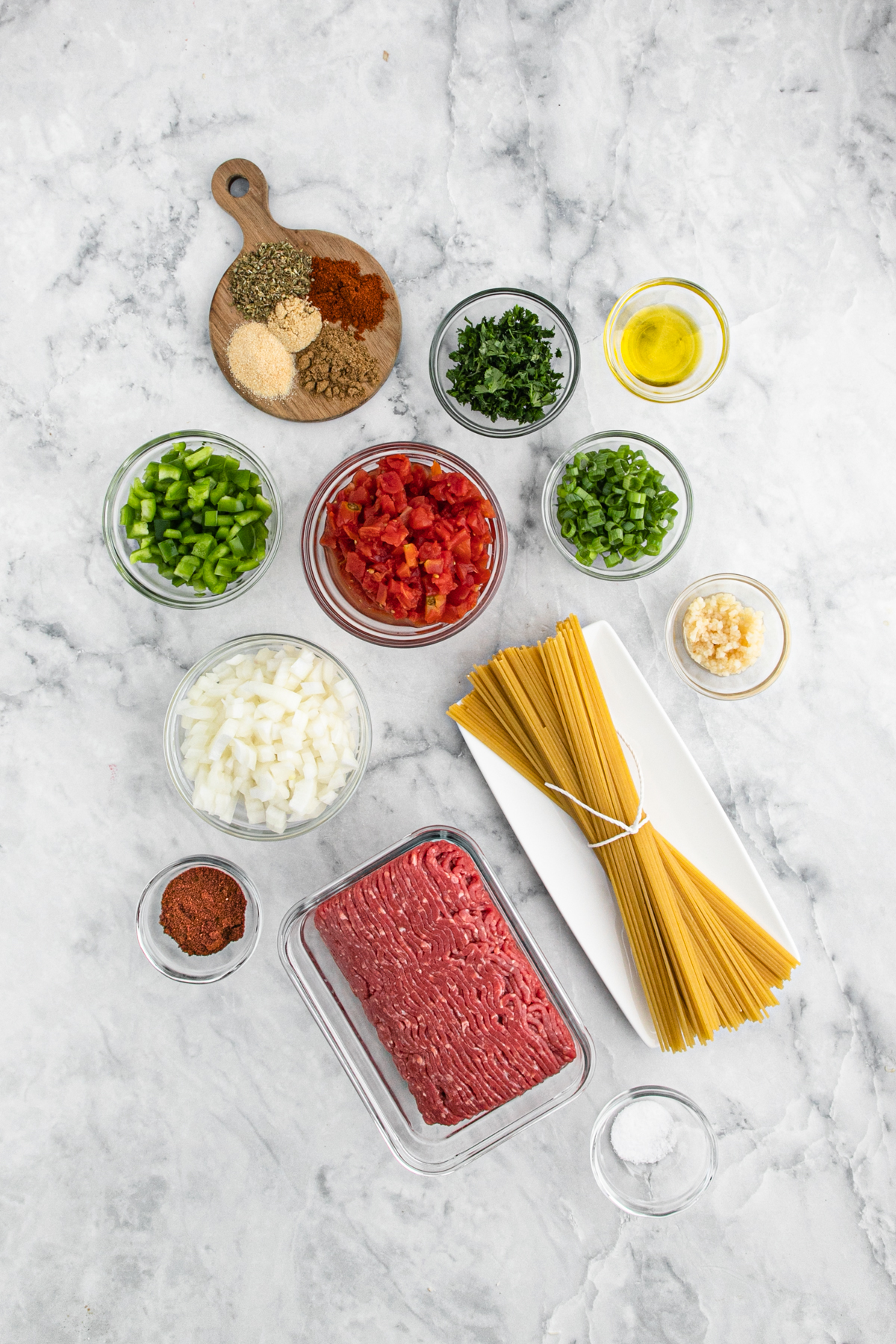 Ingredients to make a taco spaghetti recipe in separate bowls