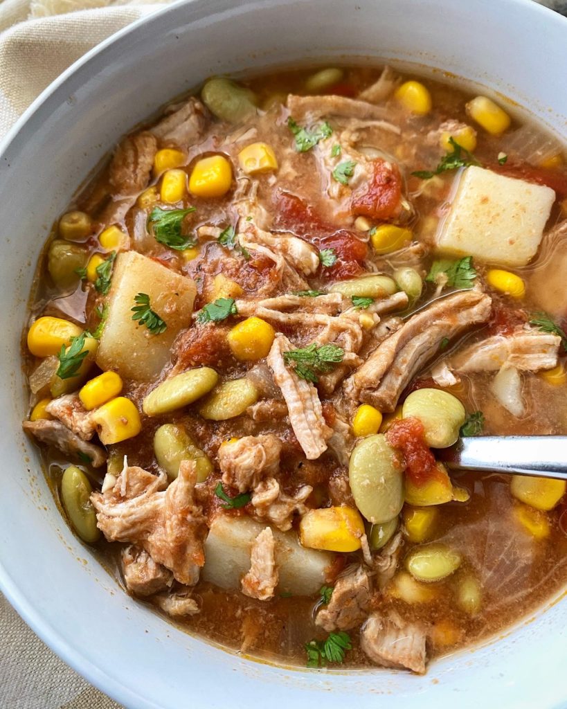 close up shot of cooked crockpot Brunswick stew in a white bowl