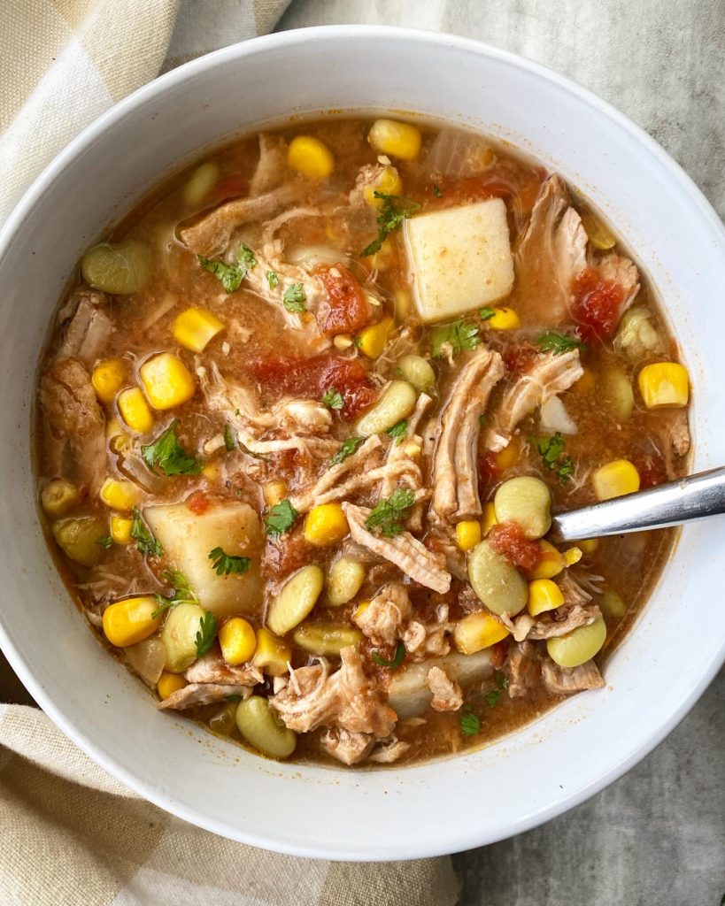 overhead shot of cooked crockpot Brunswick stew in a white bowl