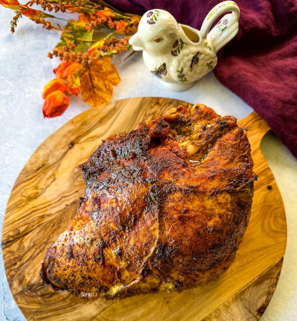 cooked, baked, roasted turkey breast on a wooden cutting board