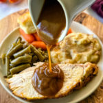 brown gravy drizzled over a slice of roasted turkey breast