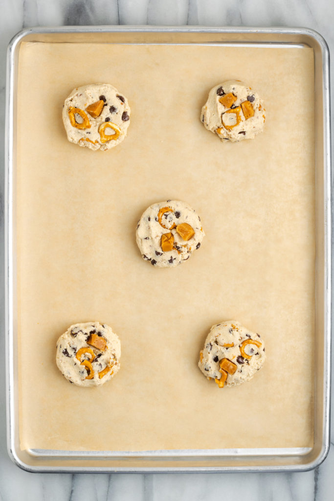 Overhead view of kitchen sink cookies on parchment-lined baking sheet before baking