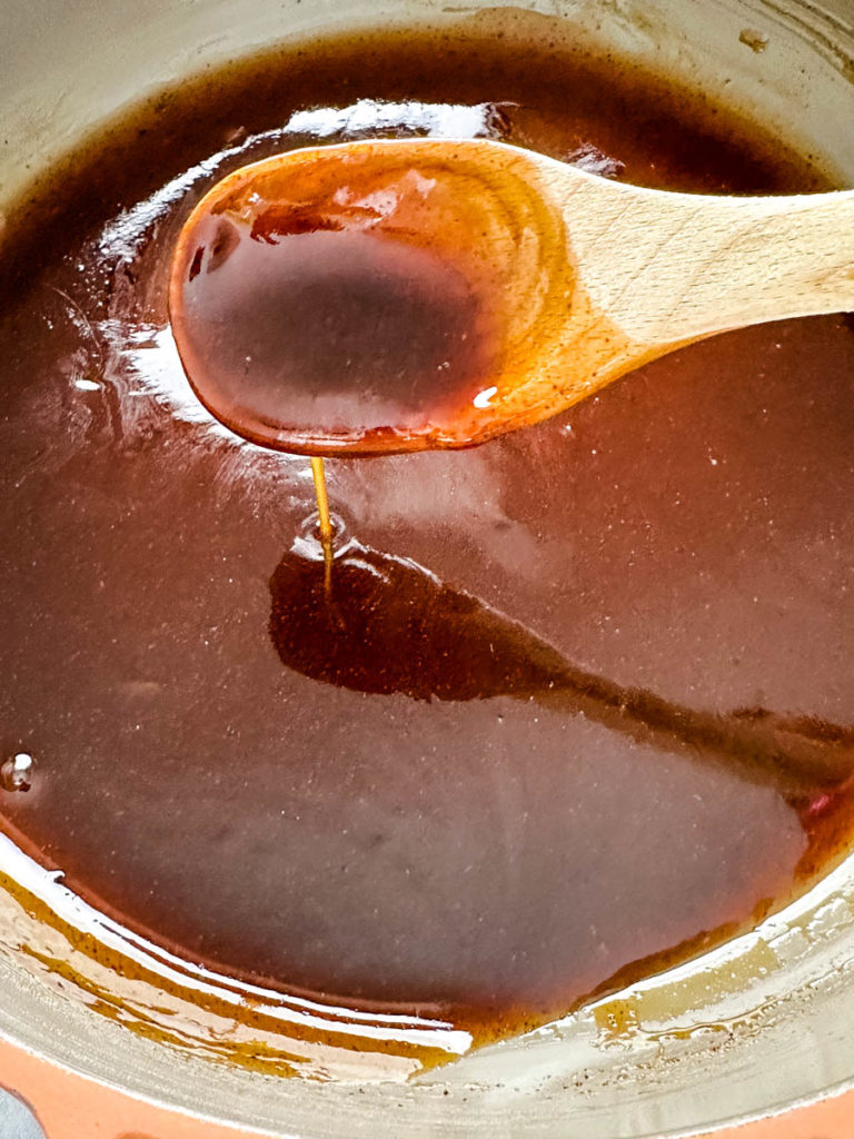honey glaze in a skillet with a wooden spoon