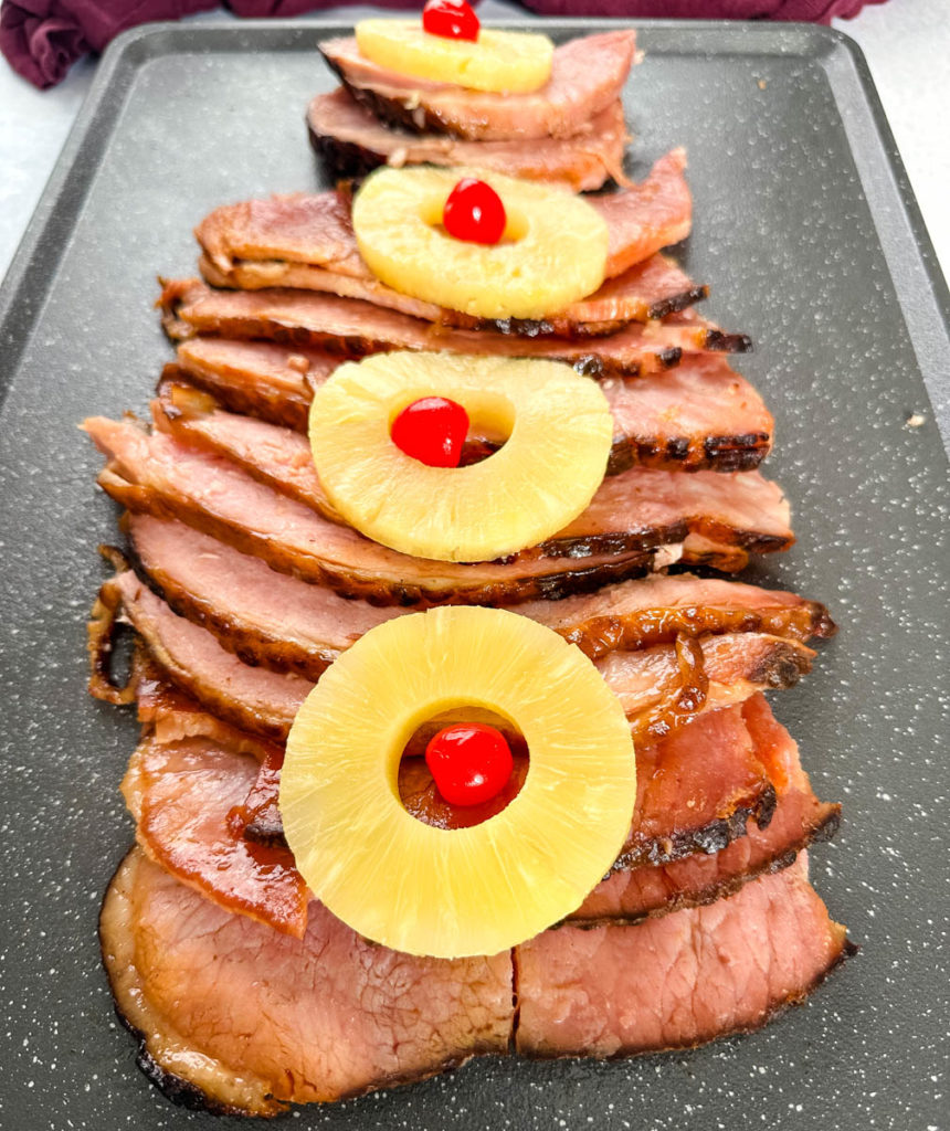 Thanksgiving and Christmas holiday ham slices on a sheet pan with pineapples and cherries