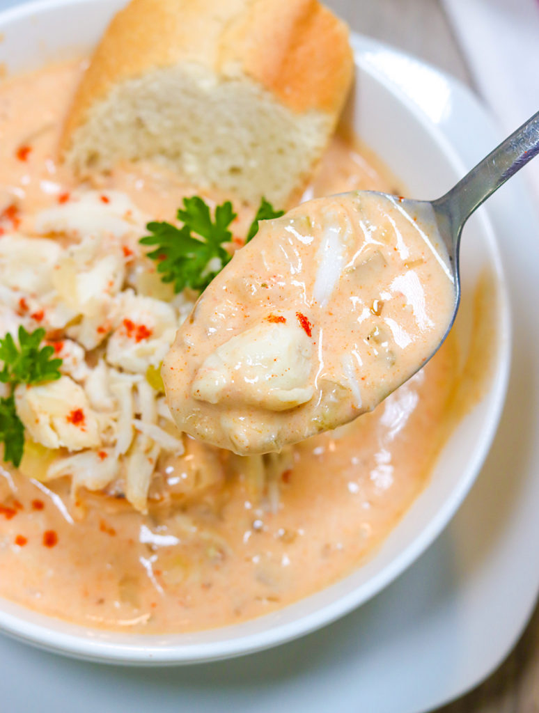 Eyeing a spoon loaded with thick and creamy she crab soup 