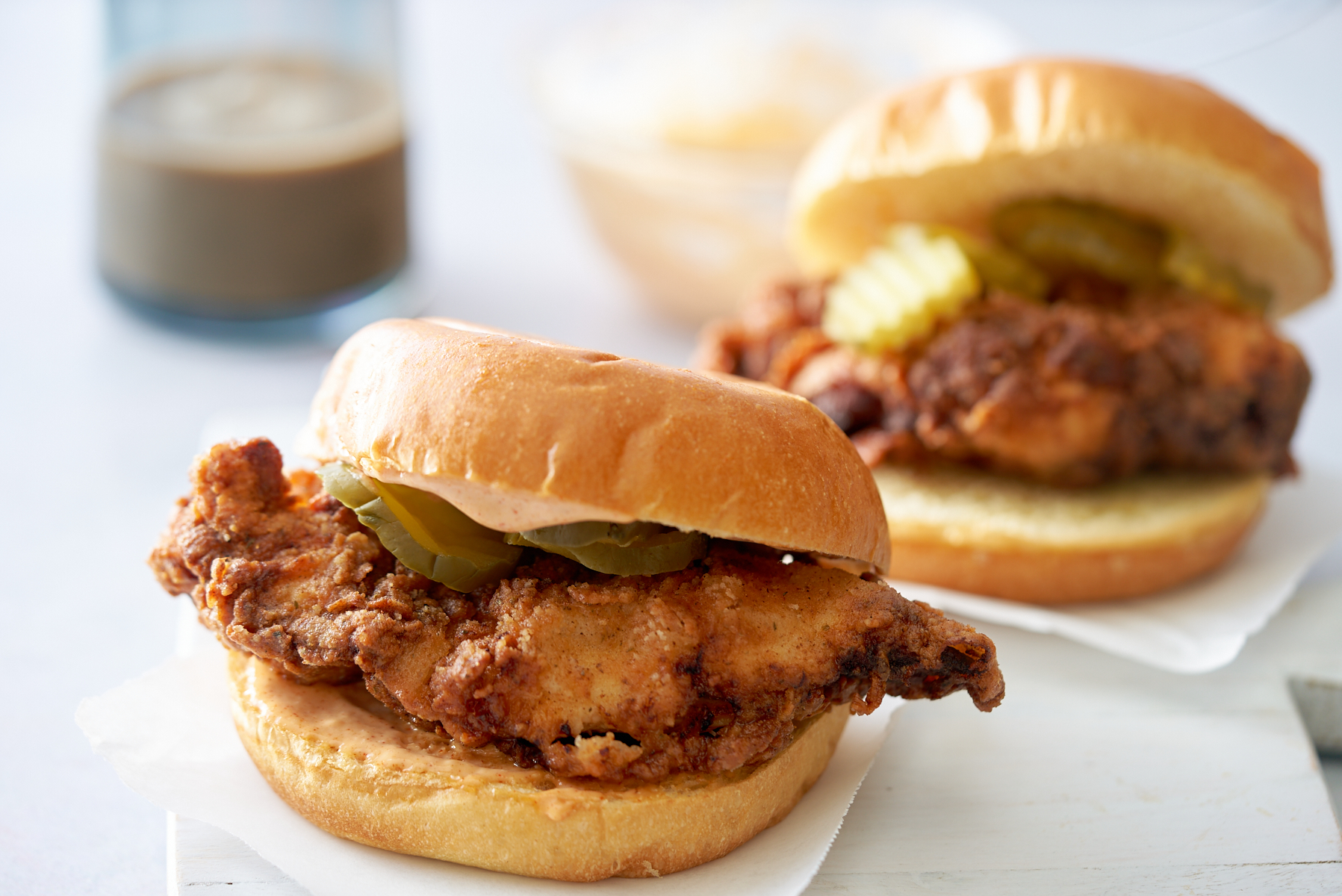 two fried chicken sandwiches on white cutting board