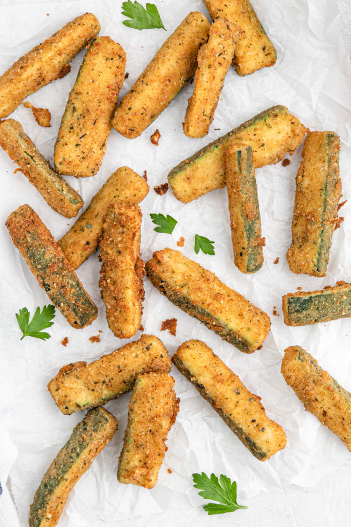 Wedges of breaded zucchini against parchment paper