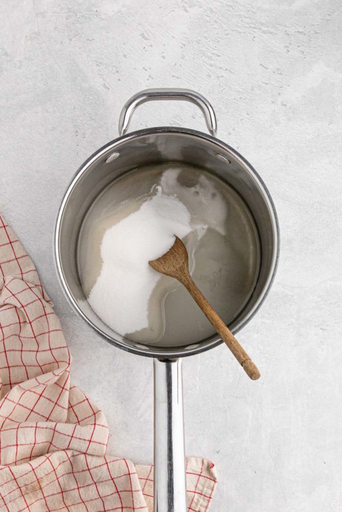 Sugar and water being stirred in pot