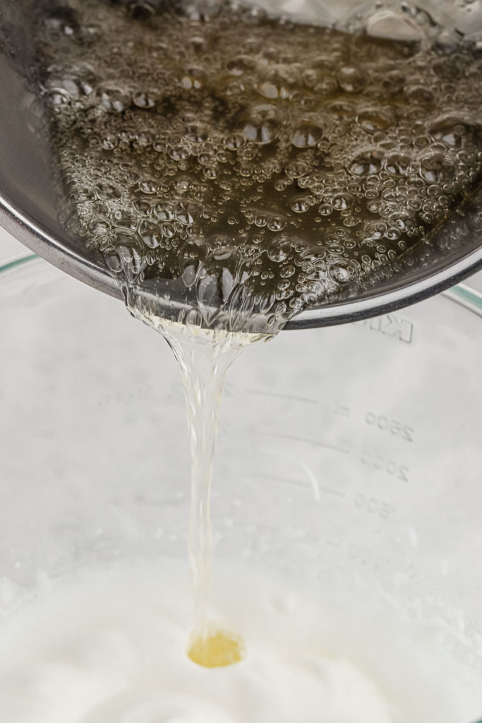 Hot sugar candy mixture being poured into egg whites