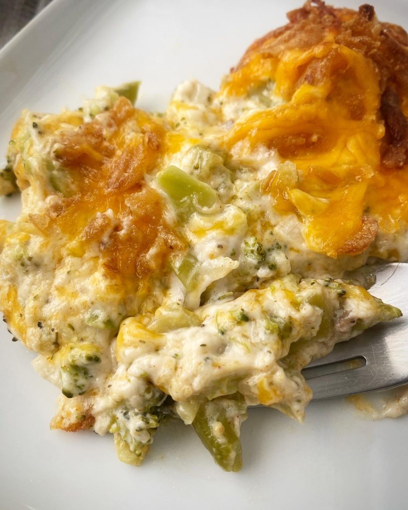 close up shot of broccoli cheese casserole on a white plate