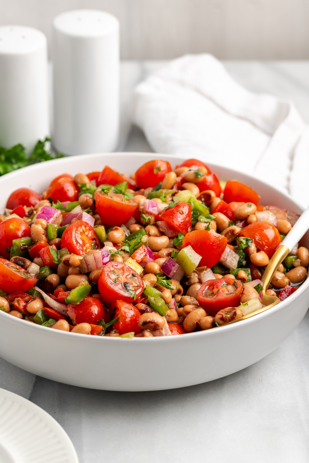 Large white bowl of black-eyed pea salad with spoon