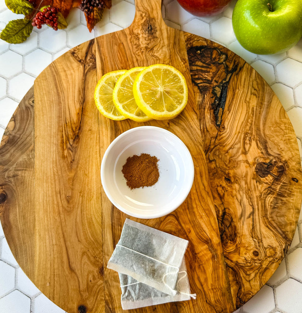 fresh lemon, cinnamon, and tea bags on a flat surface